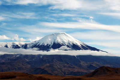 Scenic view of snowcapped mountain against cloudy sky