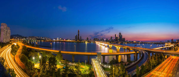 Panoramic view of illuminated bridge in city at night