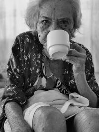 Portrait of an old woman holding a cup