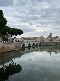 Arch bridge over river against sky