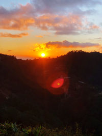 Scenic view of landscape against orange sky