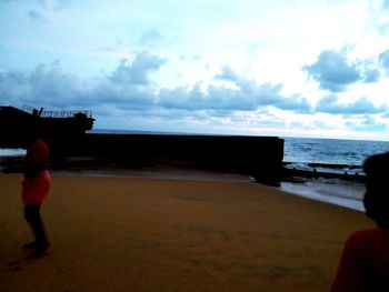 Rear view of people looking at sea against sky