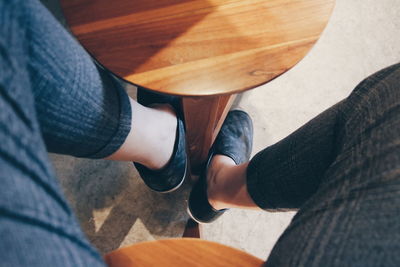 Low section of woman sitting on wooden stool