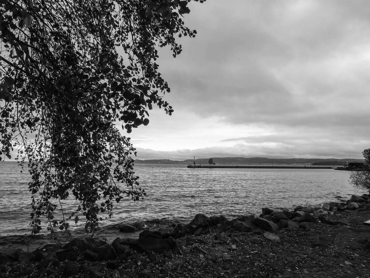 sky, water, cloud - sky, tranquility, tranquil scene, cloudy, scenics, nature, beauty in nature, sea, tree, cloud, lake, river, idyllic, overcast, weather, non-urban scene, outdoors, day