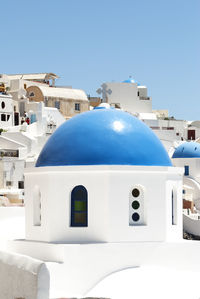 Blue dome church and houses in oia at santorini against sea