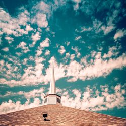 Low angle view of religious building against cloudy sky