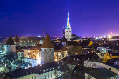 Illuminated cityscape against sky at night