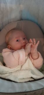 Portrait of cute baby lying on bed