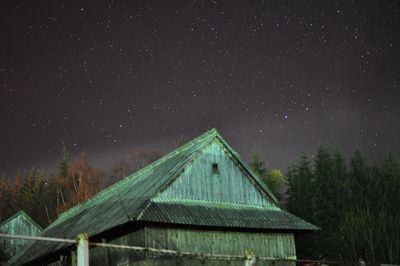 Low angle view of trees against star field