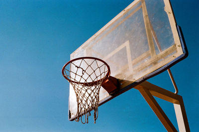 Low angle view of basketball hoop against blue sky