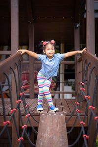 Thoughtful girl standing on jungle gym at playground