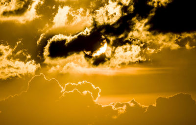 Low angle view of bright sun in sky during sunset