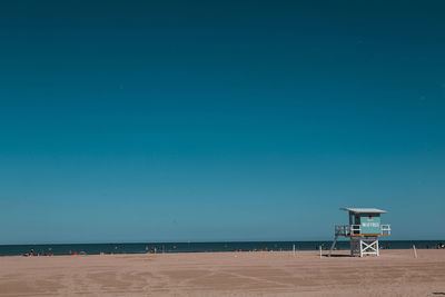 Scenic view of beach against clear blue sky