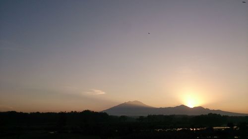 Silhouette landscape against sky during sunset