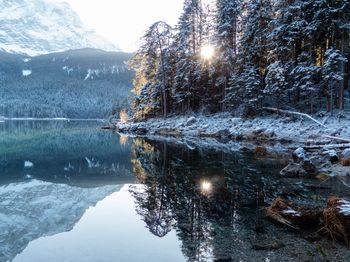 Scenic view of lake by snowcapped mountains during winter