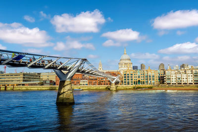 Bridge over river against cloudy sky