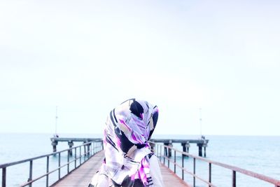 Rear view of woman on pier against sea