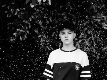 Portrait of boy standing against trees