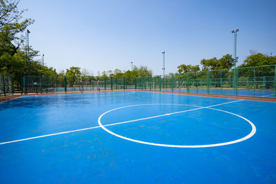 Scenic view of basketball court against clear blue sky