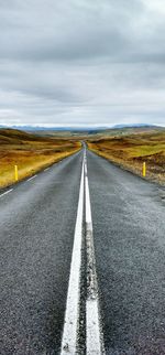 Empty road against cloudy sky