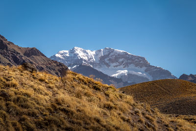 Scenic view of snowcapped mountains against clear blue sky