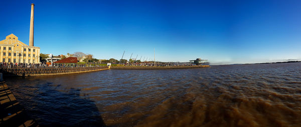 Panoramic view of sea and buildings against clear blue sky