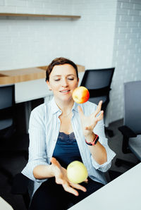 Portrait of smiling young woman using mobile phone at home