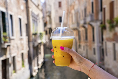 Close up of woman holding glass of fresh pineapple juice