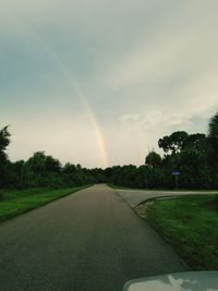 Scenic view of rainbow over field during rainy season