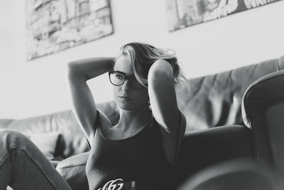 Portrait of young woman sitting on sofa at home