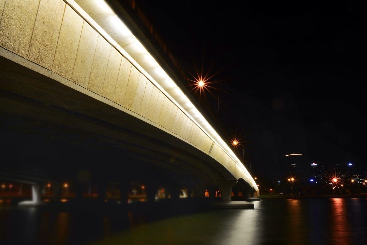 illuminated, night, architecture, built structure, transportation, city, long exposure, building exterior, lighting equipment, motion, light trail, low angle view, light - natural phenomenon, city life, glowing, blurred motion, speed, indoors, bridge - man made structure, no people