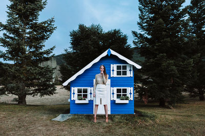 House by building and trees against sky