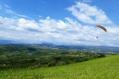 Paraglider above grassy field