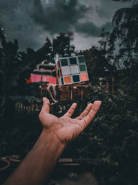 Midsection of person holding umbrella against sky