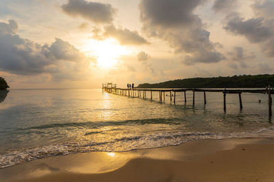 Pier over sea against sky during sunset