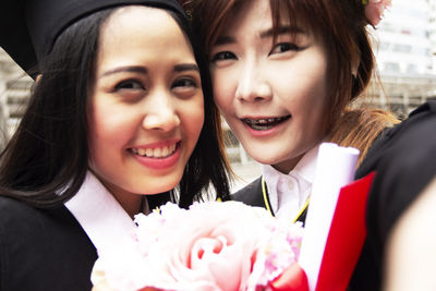 Portrait of smiling young women wearing mortar board