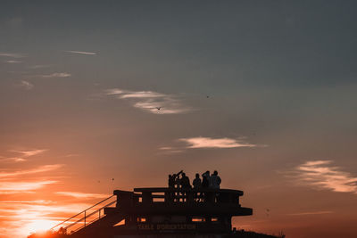 Silhouette people against sky during sunset