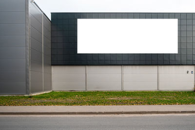 Blank white billboard for advertisement on the facade of building, outdoor advertising mockup