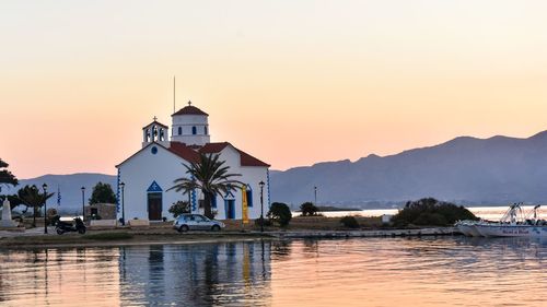 Built structure by building against sky during sunset