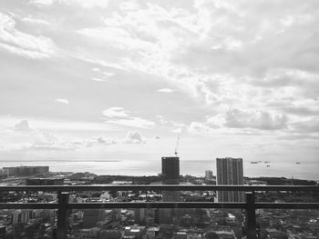 Buildings in city against cloudy sky