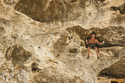 Man resting on a ledge while climbing in yangshuo / china