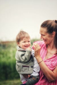 Smiling woman playing with son