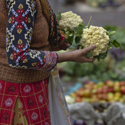 Midsection of woman holding ice cream at market