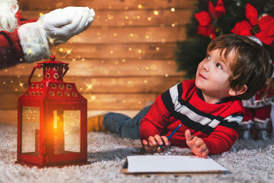 Side view of boy playing with christmas tree trunk