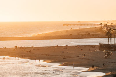 Scenic view of beach against clear sky during sunset