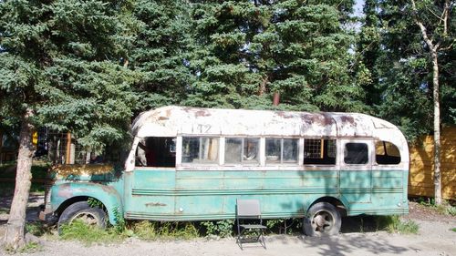 Abandoned vintage car against trees