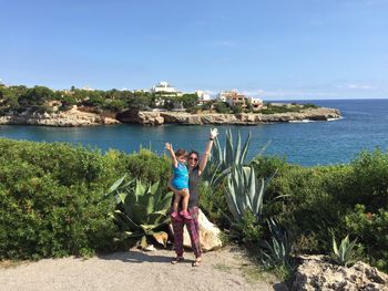 Portrait of boy standing on beach against sky