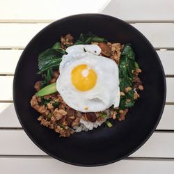 High angle view of fried egg in cooking pan on table