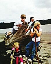 Happy friends standing at sea shore