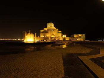 Illuminated temple against clear sky at night